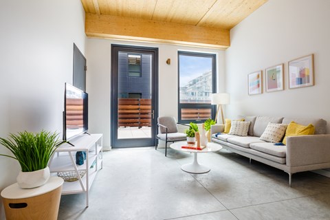 a living room with couches and a table and a sliding glass door
